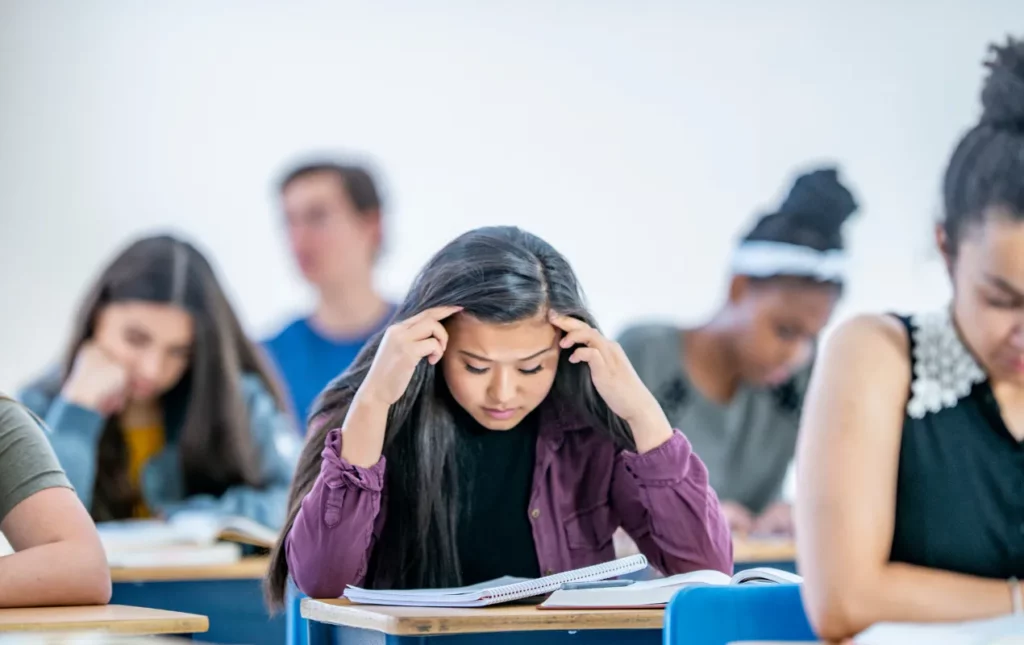 Une étudiante dans une salle de classe stressée par ses cours.