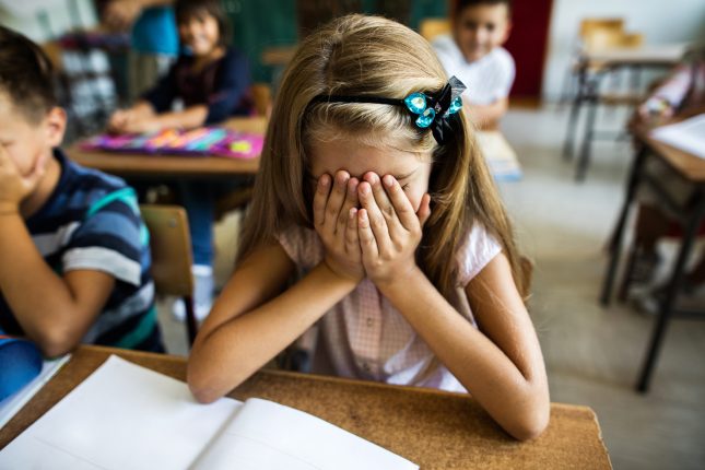 une enfant stressée à l'école qui a la tête dans les mains