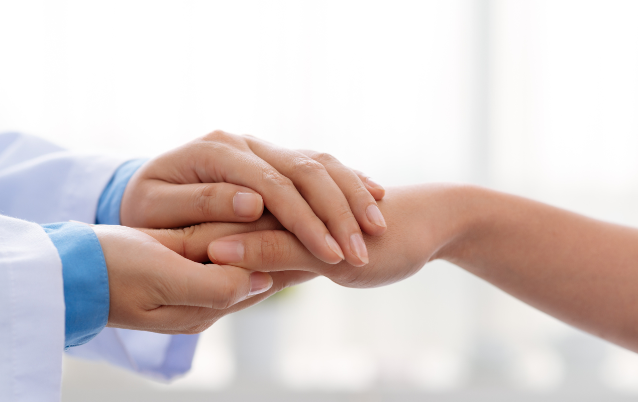 Les mains d'un médecin enveloppant une main d'un patient pour montrer son empathie et sa compassion. 